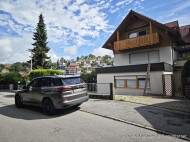 Blick zur Wohnung und Stellplatz hinter dem Zaun